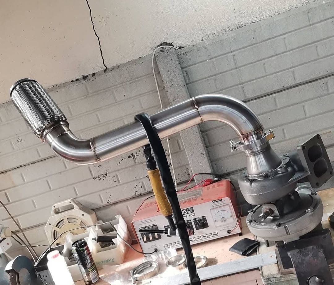 Mazda FC RX-7 turbo and fabricated stainless downpipe on the workshop bench